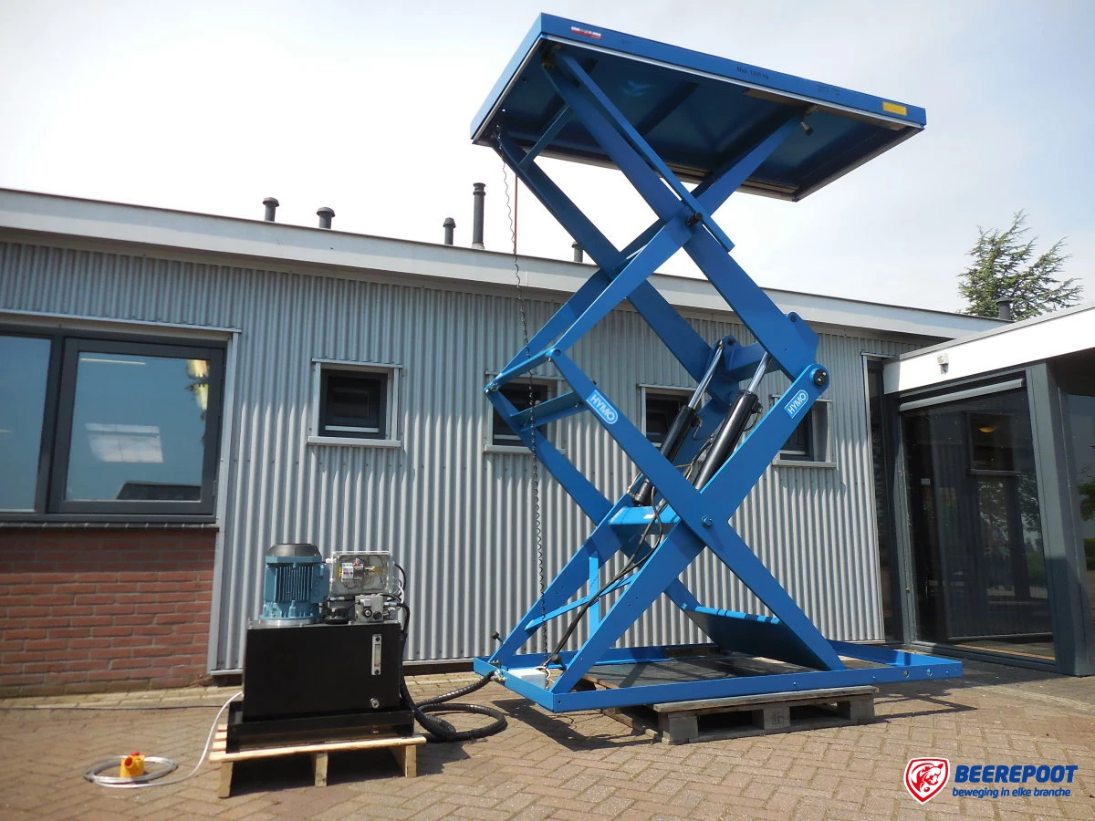 Je ziet een hoge blauwe verticaal dubbelscharende heftafel van Beerepoot die buiten staat bij Beerepoot.